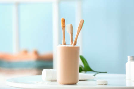 Tooth brushes in holder on table in bathroomの写真素材