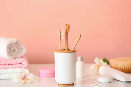 Tooth brushes in holder on table in bathroomの写真素材