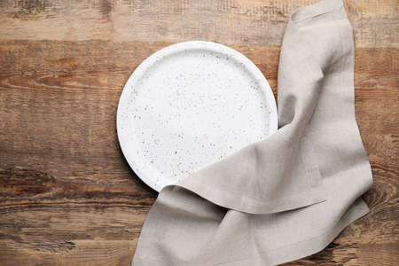 Clean napkin with plate on wooden backgroundの写真素材