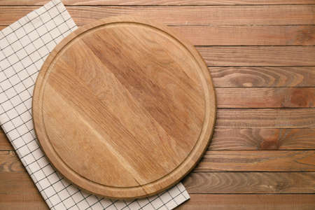 Clean napkin with cutting board on wooden backgroundの写真素材