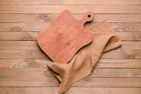 Clean napkin with cutting board on wooden backgroundの写真素材