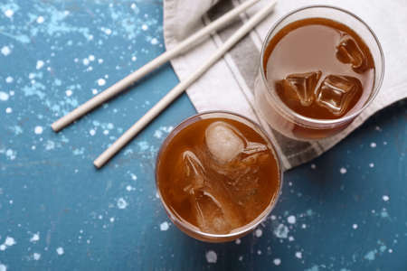 Glasses of tasty iced coffee on color backgroundの写真素材