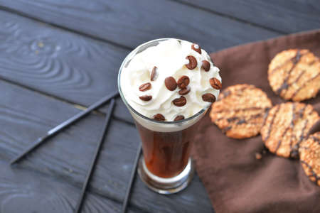 Glass of tasty iced coffee on table