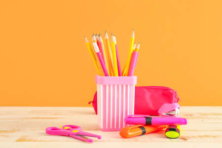 Holder with stationery on table against color backgroundの写真素材