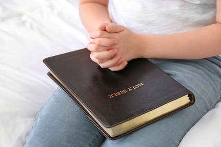 Cute little girl praying at home, closeup