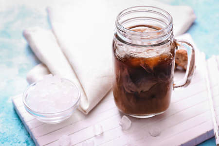 Mason jar of tasty iced coffee on table