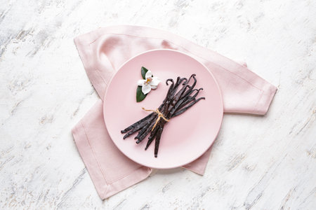 Plate with aromatic vanilla sticks on light backgroundの写真素材