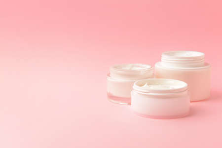 Jars of cosmetic cream on color backgroundの写真素材