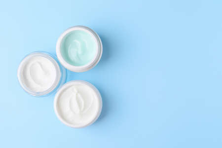 Jars of cosmetic cream on color backgroundの写真素材