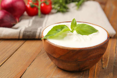 Bowl with tasty sour cream on tableの写真素材