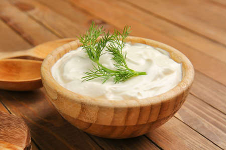 Bowl with tasty sour cream on tableの写真素材