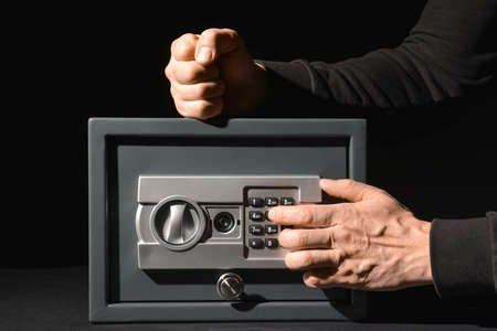 Burglar breaking safe box on dark backgroundの写真素材