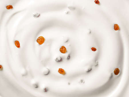 Tasty yogurt with raisins as background, closeupの写真素材
