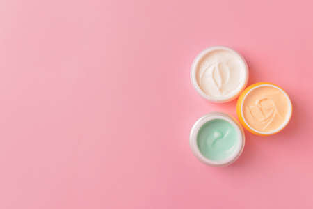 Jars of cosmetic cream on color backgroundの写真素材