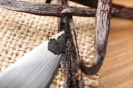 Knife and aromatic vanilla sticks on wooden background, closeupの写真素材