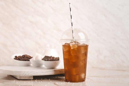 Cup of tasty cold coffee on light backgroundの写真素材