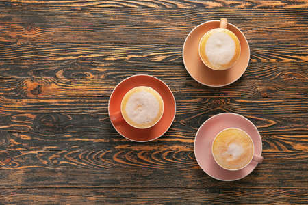 Cups of hot coffee on wooden tableの写真素材
