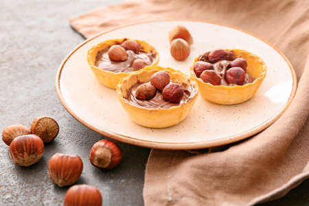 Plate with tartlets and tasty chocolate paste on gray backgroundの写真素材