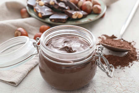 Jar with tasty chocolate paste on light backgroundの写真素材