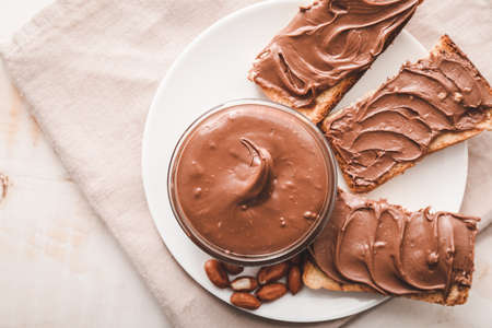 Plate with fresh bread and chocolate paste on tableの写真素材
