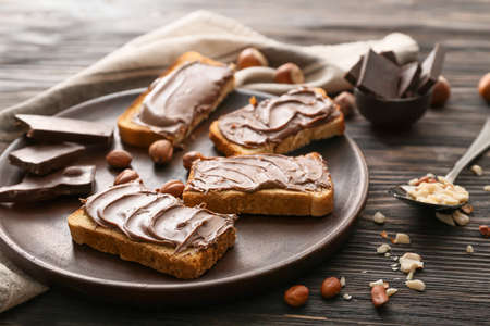 Plate with fresh bread and chocolate paste on tableの写真素材