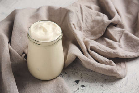 Jar of tasty sour cream on light tableの写真素材