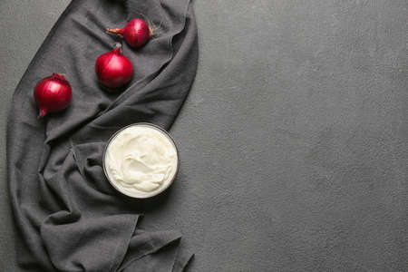 Bowl of tasty sour cream and onion on tableの写真素材