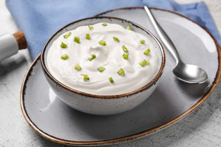 Bowl of tasty sour cream on tableの写真素材