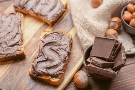 Board with fresh bread and chocolate paste on tableの写真素材