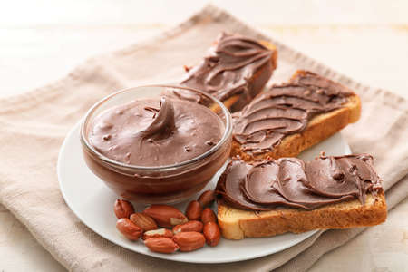 Plate with fresh bread and chocolate paste on tableの写真素材