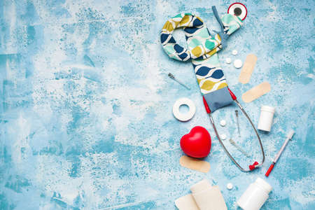 Stethoscope with cover, heart and supplies on color backgroundの写真素材