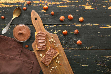 Board with fresh bread and chocolate paste on tableの写真素材