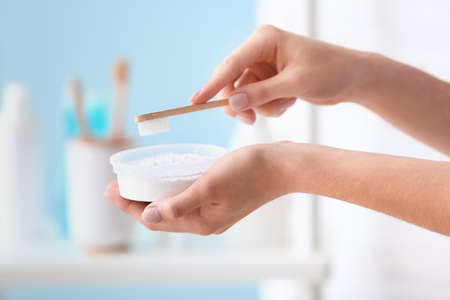 Woman with tooth brush and powder in bathroomの写真素材