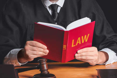 Male judge with book at table, closeup