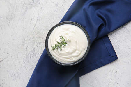 Bowl of tasty sour cream on light tableの写真素材