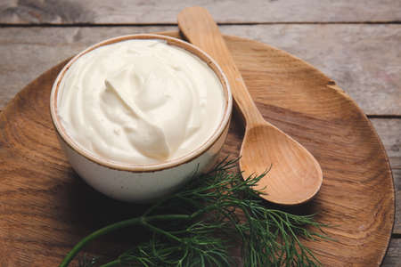 Bowl of tasty sour cream on tableの写真素材