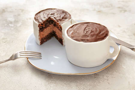 Chocolate cakes in shape of coffee cups on color backgroundの写真素材