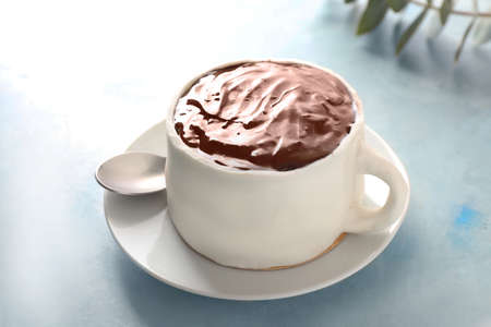 Chocolate cake in shape of coffee cup on color backgroundの写真素材