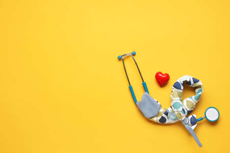 Stethoscope with cover and heart on color backgroundの写真素材