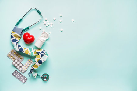 Stethoscope with cover, heart and pills on color backgroundの写真素材