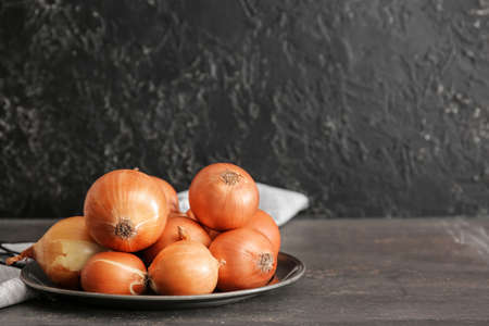 Plate with fresh raw onion on tableの写真素材