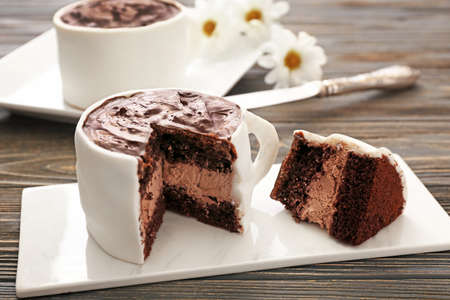 Chocolate cake in shape of coffee cup on tableの写真素材