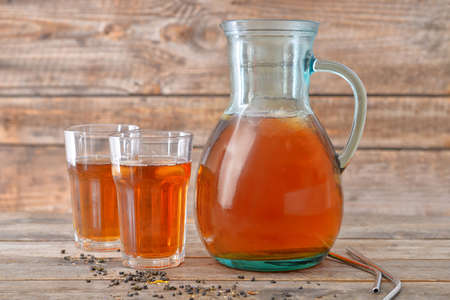 Jug and glasses of tasty cold tea on wooden tableの写真素材