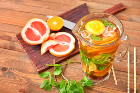 Jug of tasty cold tea on wooden tableの写真素材