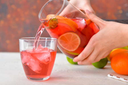 Pouring of tasty cold tea into glass on tableの写真素材