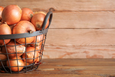 Basket with fresh raw onion on wooden backgroundの写真素材