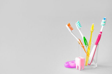 Glass with tooth brushes on light backgroundの写真素材