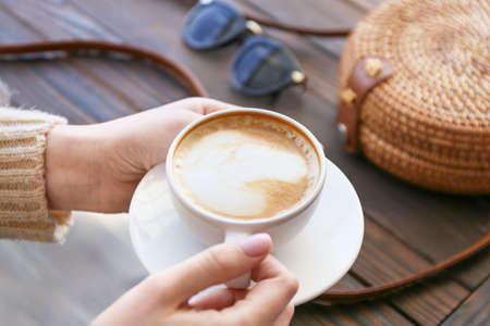 Woman drinking tasty cappuccino in cafeの写真素材