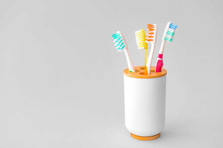 Holder with tooth brushes on light backgroundの写真素材