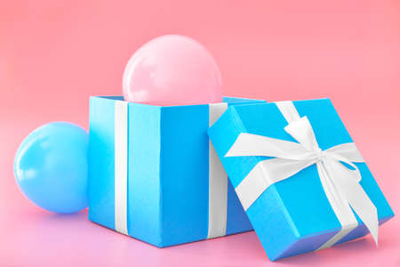 Birthday gift box with air balloons on color backgroundの写真素材